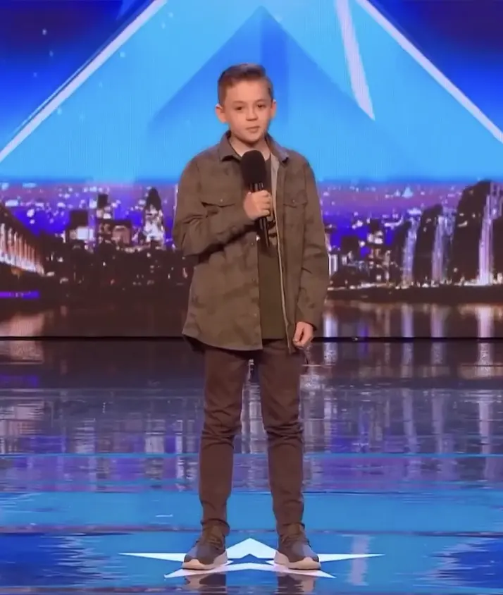 A young boy stands on stage, visibly nervous before his life-changing performance.